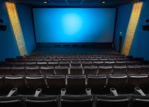 Zdjęcie przedstawia salę kinową z krzesłami i ekranem